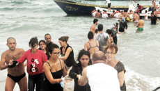 Siracusa, lo sbarco di profughi siriani assistiti da bagnanti